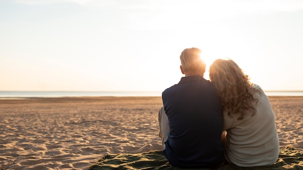 Foto paar sitzt am strand voller schuss