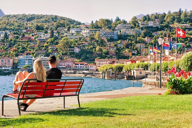 Paar sitzt auf der Bank an der Promenade des luxuriösen Resorts in Ascona am Lago Maggiore im Kanton Tessin in der Schweiz.