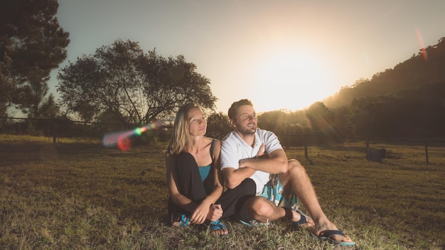 Paar sitzt bei Sonnenuntergang im Park auf dem Gras