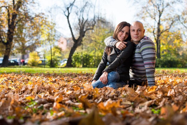 Paar sitzt im Herbst zusammen im Wald