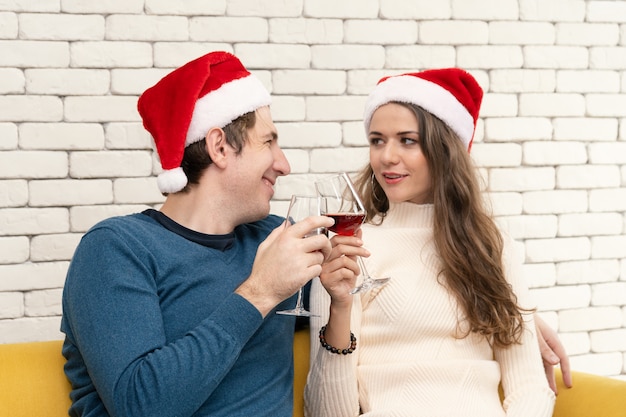 Paar sitzt und trinkt Rotwein auf dem Sofa.