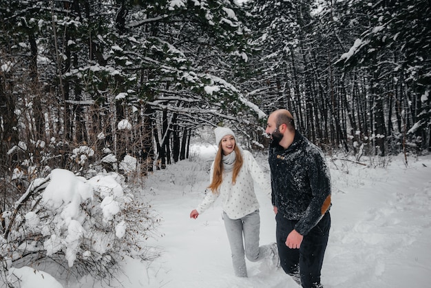 Paar spielt mit Schnee im Wald