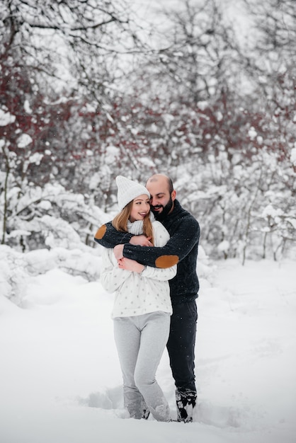 Paar spielt mit Schnee im Wald