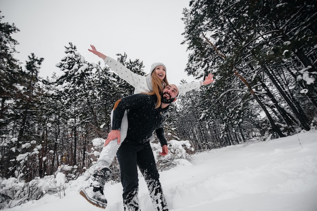 Paar spielt mit Schnee im Wald