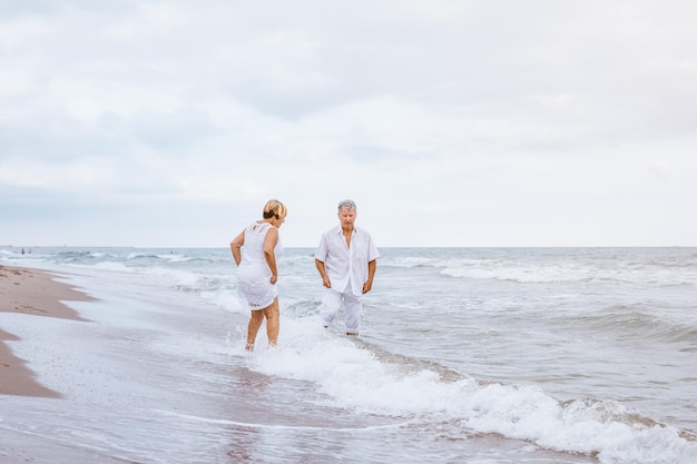 Foto paar steht am strand und der himmel ist bewölkt.