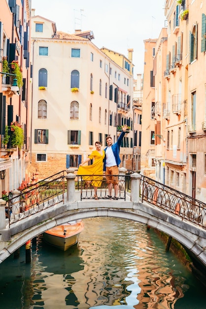 Paar steht auf der Brücke, die die Kanäle von Venedig überquert