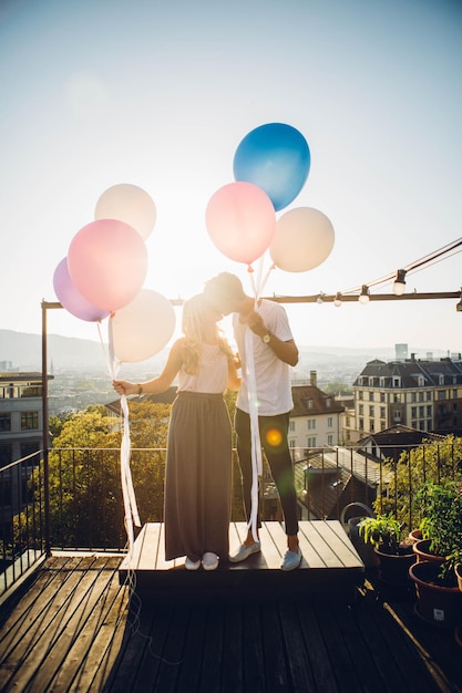 Foto paar steht mit ballons gegen den himmel