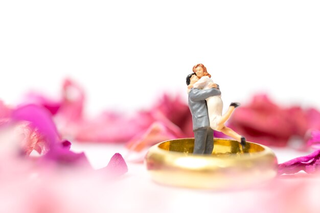 Paar umarmen im rosa Garten mit einem Ehering