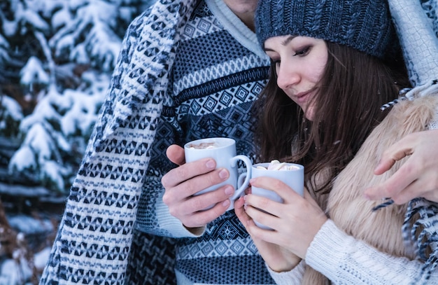 Paar umarmt und hält Tasse Kaffees mit Eibisch