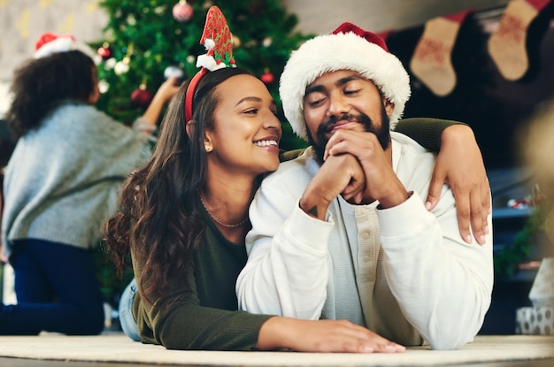 Paar umarmt Weihnachten und Liebe bei Partyfeiern und Glück im Urlaub im heimischen Wohnzimmer Mann, Frau und Umarmung, um Romantik und Freude mit Lächeln, Pflege und Lounge im Familienheim zu feiern