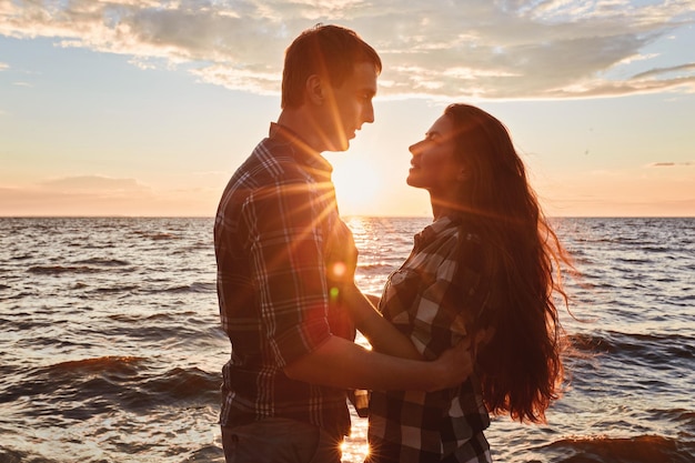 Paar verliebtes Gegenlichtschattenbild am See-Sonnenuntergang