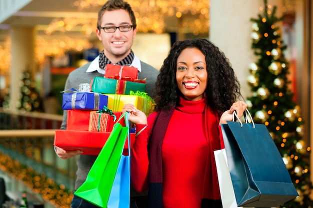 Paar Weihnachtseinkäufe mit Geschenken im Einkaufszentrum