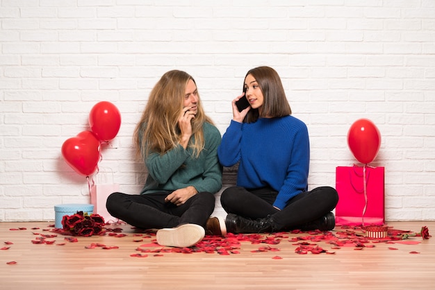 Paare am Valentinstag, der ein Gespräch mit dem Handy hält