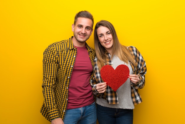 Paare am Valentinstag, der ein Herzsymbol hält