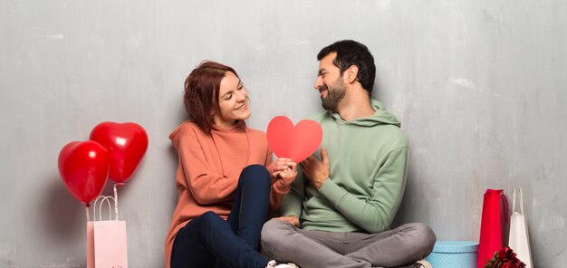 Paare am Valentinstag, der ein Herzsymbol hält