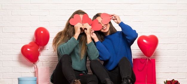 Paare am Valentinstag, der ein Herzsymbol hält