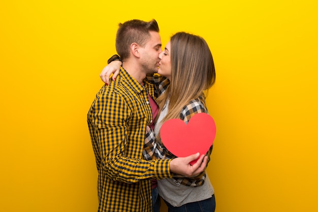Paare am Valentinstag, der ein Herzsymbol und ein Küssen hält