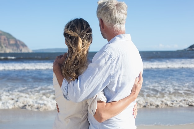 Paare auf dem Strand, der heraus zum Meer schaut