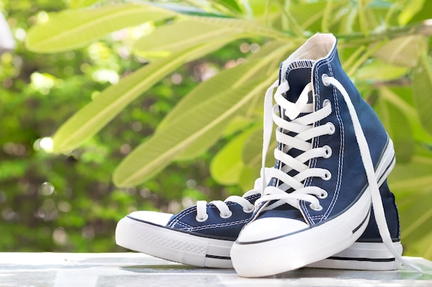 Paare der neuen blauen Turnschuhe auf Tischplattenperspektive und naturel Hintergrund