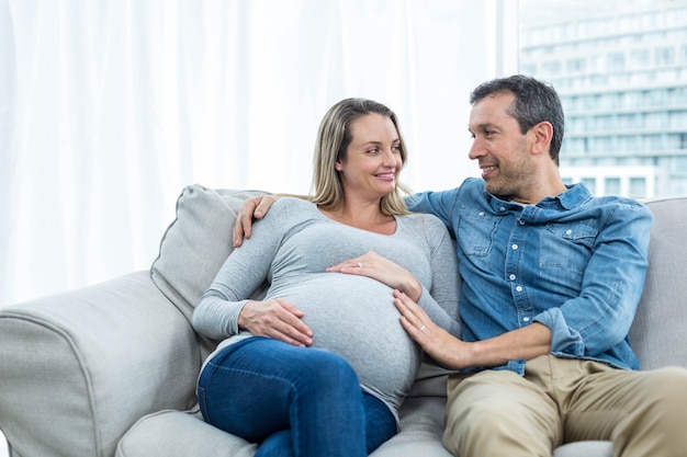 Paare, die auf Sofa sitzen und einander betrachten