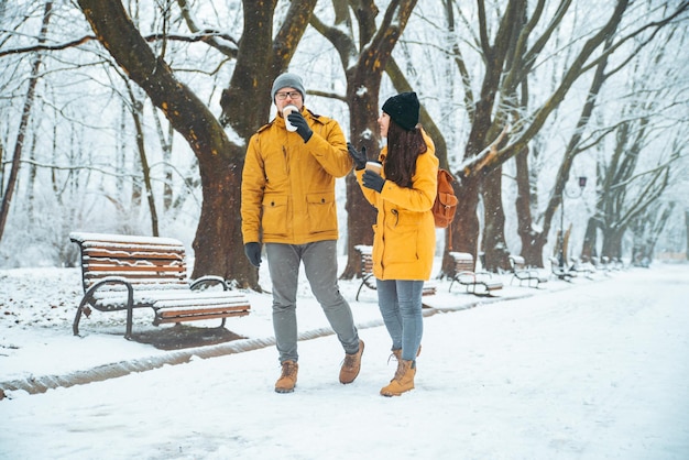 Paare, die durch den verschneiten Stadtpark gehen und Geselligkeit sprechen. romantisches Date im Winter. Weihnachten steht vor der Tür