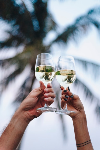 Paare, die ein Glas Wein am Strand genießen