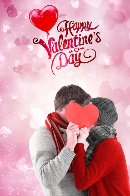 Paare, die ein rotes Herz gegen Valentinsgrußherzdesign halten