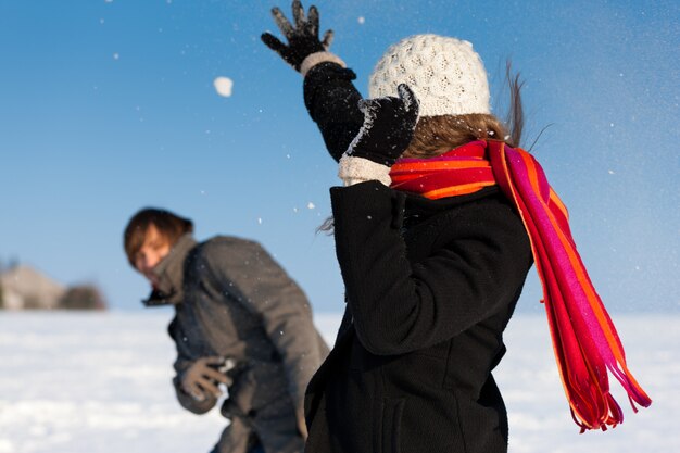 Paare, die eine Schneeballschlacht im Winter haben