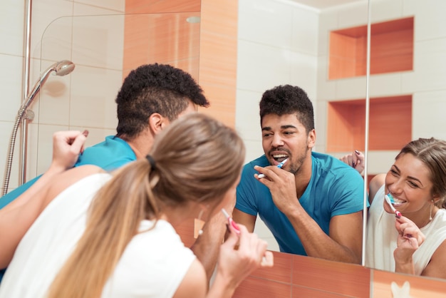 Paare, die ihre Zähne im Badezimmer putzen