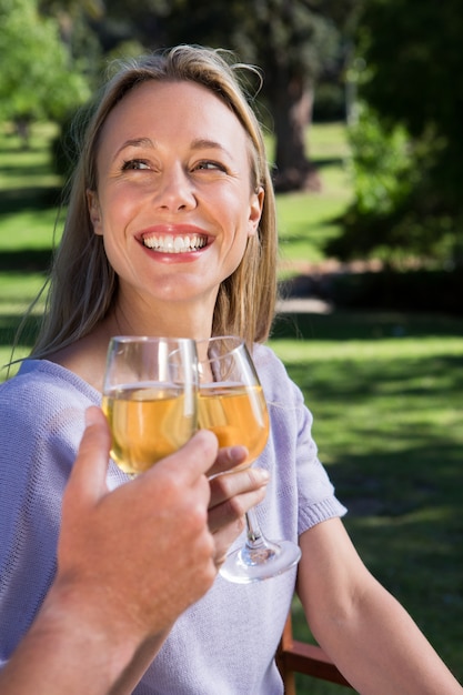 Paare, die im Park mit Wein sich entspannen