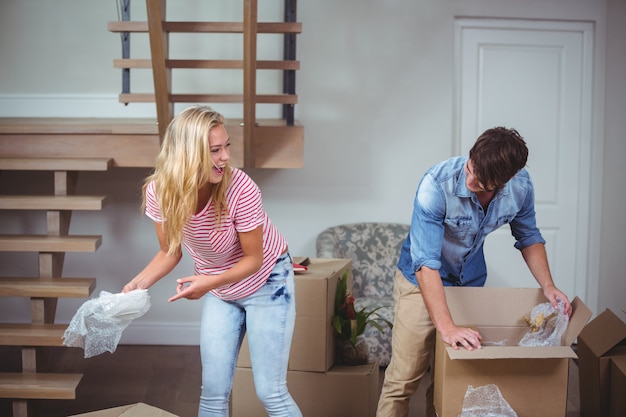 Paare, die Kästen im neuen Haus auspacken