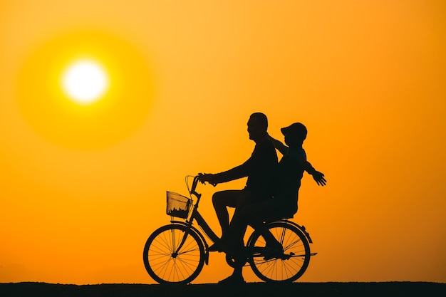 Paare, die mit dem Fahrrad den Sonnenuntergang beobachten