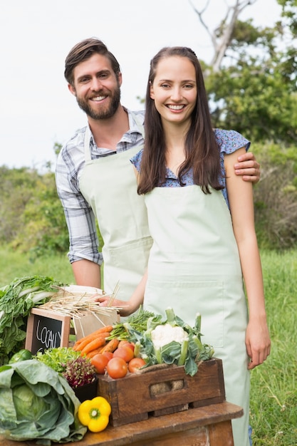 Paare, die organisches Gemüse am Markt verkaufen