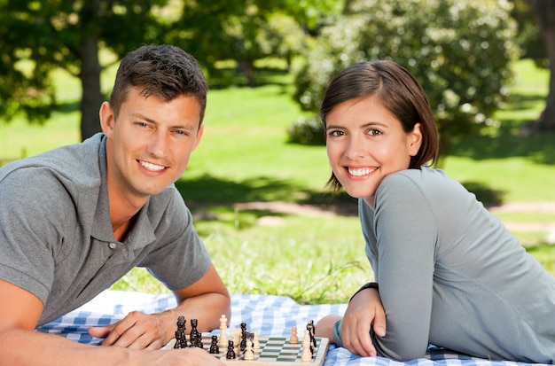 Paare, die Schach im Park spielen