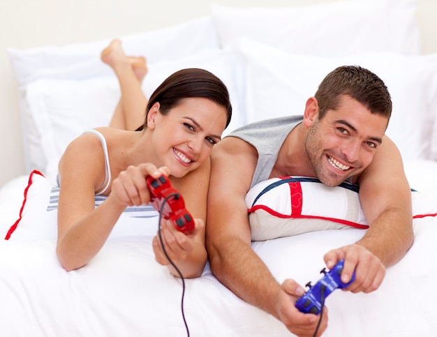 Paare, die Videospiele im Bett spielen