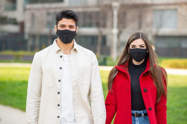 Paare, die während einer Covid- oder Coronavirus-Pandemie zusammen in einer Stadt spazieren gehen