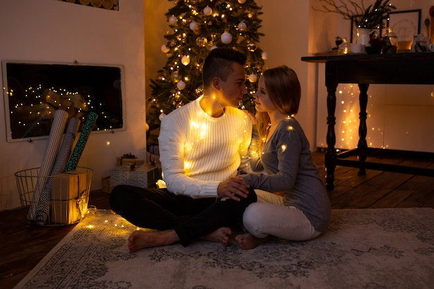 Paare, die zu Hause zur Weihnachtszeit umarmen