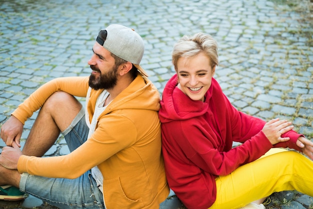 Paare hängen zusammen ab. Unbeschwerte Menschen. Die Jugend will einfach nur Spaß haben. Freiheitsgefühl. Jugendmode. Fühlen Sie sich frei und stilvoll. Mann und Frau moderne Kleidung für die Jugend, die sich im Freien entspannt. Für immer jung