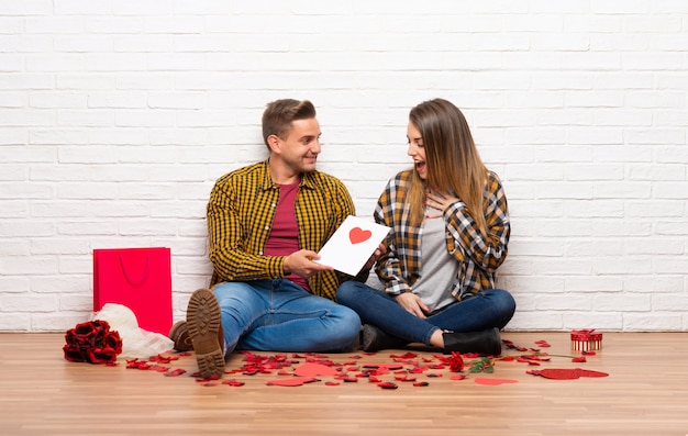 Paare im Valentinstag zuhause mit Valentinsgrußtageskarte