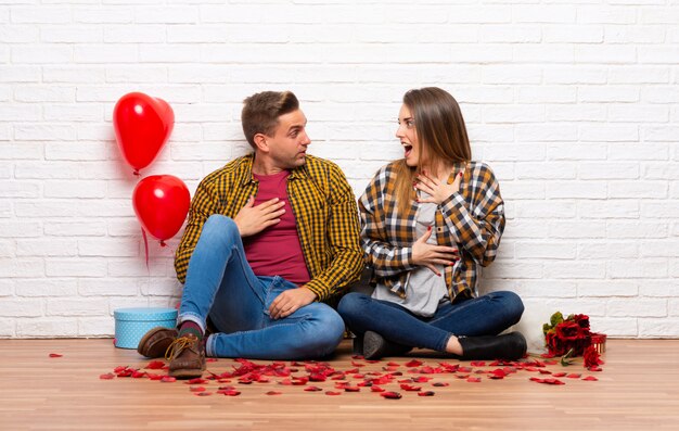 Paare im Valentinstag zuhause zuhause mit Überraschung und entsetztem Gesichtsausdruck