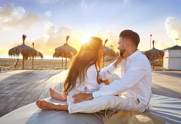 Paare jung im strandferiensonnenaufgang