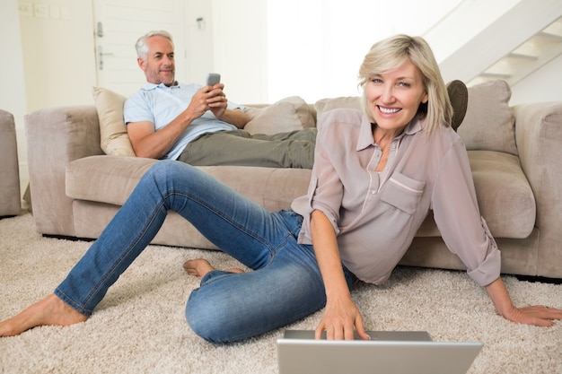 Paare mit Laptop und Mobiltelefon im Wohnzimmer zu Hause