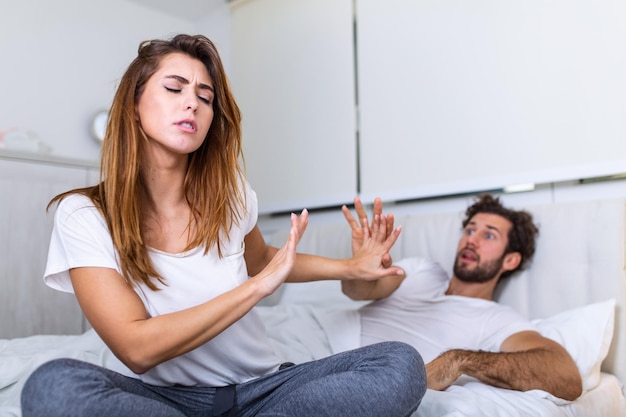 Foto paare mit problemen, die uneinigkeit im bett haben. frustriertes paar streitet und hat eheprobleme, junges paar in streit auf dem bett im schlafzimmer