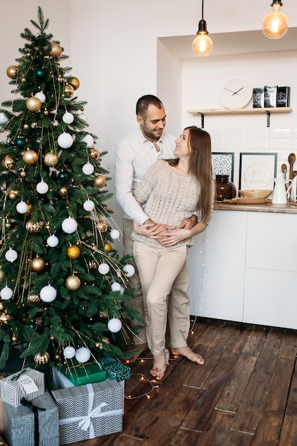 Paare nahe Weihnachtsbaum auf Weihnachten zu Hause in der Küche