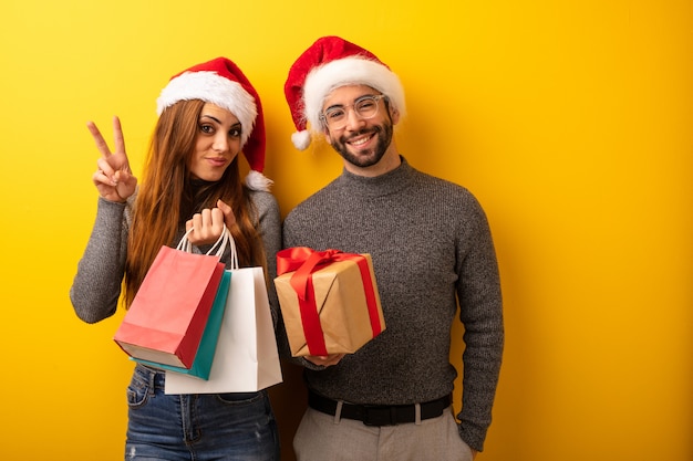 Paare oder Freunde, die Geschenke halten und Einkaufstaschen, die Nummer zwei zeigen