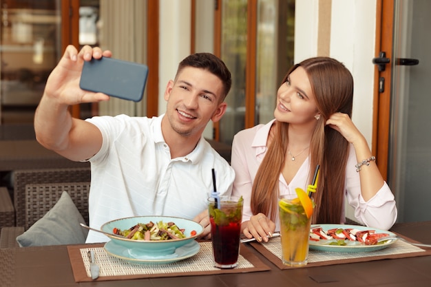 Paare unter Verwendung des Handys im Café