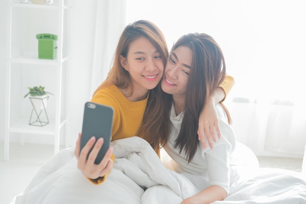 Paare von den lächelnden jungen Frauen, die selfie mit intelligentem Telefon machen.