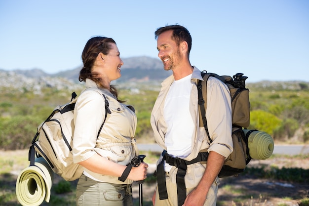 Paare wandern an einander in der Landschaft wandern