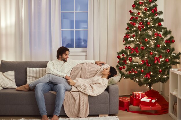 Paarfeier neues Jahr in der Nähe von Weihnachtsbaum zu Hause