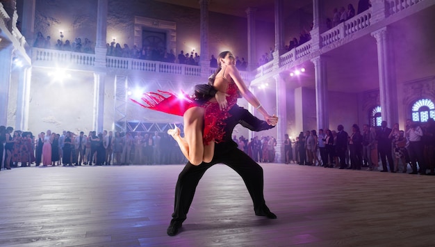 Paartänzer führen lateinamerikanischen Tanz auf großer professioneller Bühne Gesellschaftstanz auf